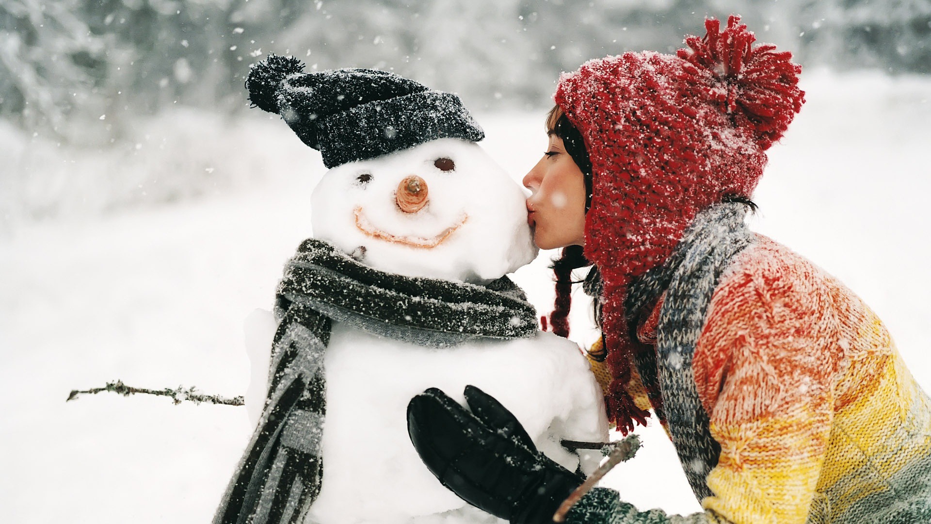 Beautiful girl kiss snowman